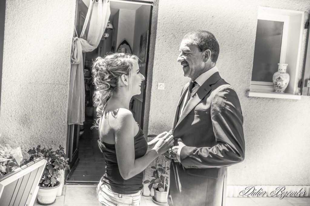 photos de mariage en noir et blanc prise pendant les préparatifs montre un instant de tendresse entre la future mariée et sont papa photographie-des-préparatifs-de-marié-en-noir-et-blanc-instant-d'intimité-entre-la-mariée-photographe-Didier-Bezombes